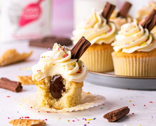 Vanilla cupcake with a chocolate ganache center, topped with vanilla buttercream, colorful sprinkles, and a Cadbury Flake, inspired by the classic 99 ice cream