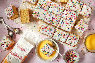 an old school traybake sliced and served with bowls of custard