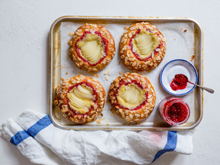 Pear & Raspberry Jam Brioche Tarts topped with sliced pears, almond flakes, served with raspberry jam on the side.