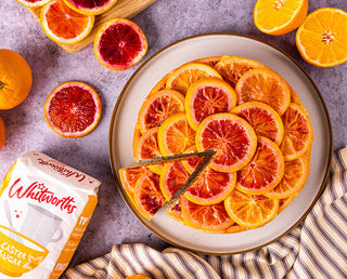 Slice taken out of an Orange up-side cake served on a plate