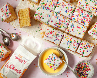 an old school traybake sliced and served with bowls of custard