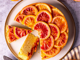 Slice taken out of an Orange up-side cake served on a plate