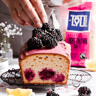 Loaf cake with blackberries on top, Tate & Lyle Light Soft Brown sugar packet in the background