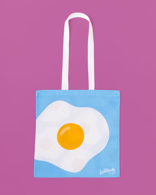 Tote bag with a fried egg design on a purple background