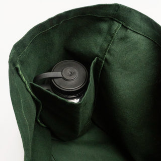A close-up of a dark green canvas water bottle carrier pouch holding a black insulated bottle with a lid and carry loop, set against a plain white background.