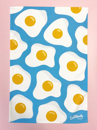 Tea towel with fried egg pattern on a blue background