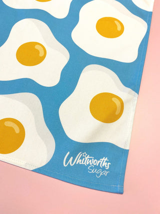 Whitworths Sugar tea towel with fried egg design on a blue background