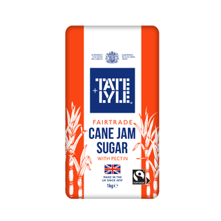 A 1kg bag of Tate & Lyle Fairtrade Cane Jam Sugar with Pectin, featuring a white and orange design with illustrations of sugarcane leaves and a blue brand logo.